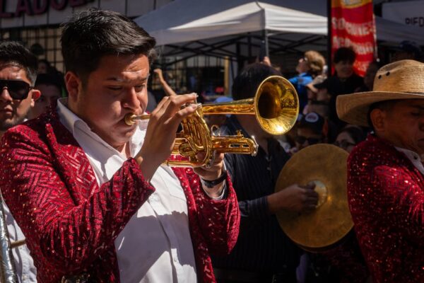 A vibrant brass band plays during a lively street carnival in Hidalgo, Mexico.