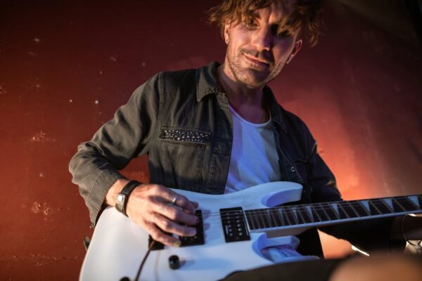 Guitarist performing live with an electric guitar, conveying passion and energy.