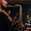 A saxophonist playing in a jazz band, highlighting the instruments and live performance atmosphere.