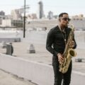 A musician plays saxophone on a city rooftop, creating a vibrant, urban vibe.