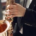 Elegant close-up of a musician playing a saxophone at a live performance, showcasing skill and style.