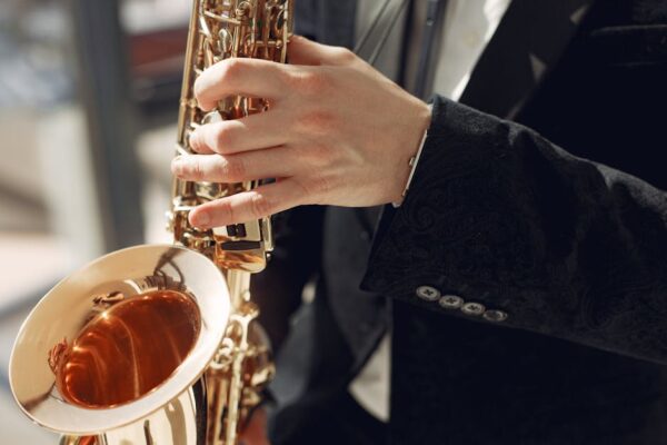 Elegant close-up of a musician playing a saxophone at a live performance, showcasing skill and style.