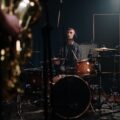 Musician playing drums in a sound studio, captured during a recording session.