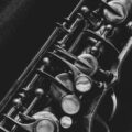 Artistic black and white close-up of saxophone keys, highlighting intricate details.