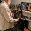 An elderly man explores a collection of vintage vinyl records in a cozy indoor setting.