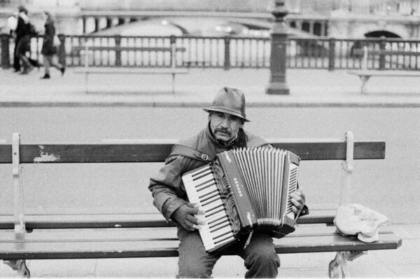 A street musician plays the accordion on a bench in Paris, France.