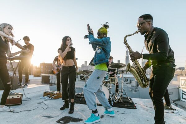 Vibrant music group performing live on a rooftop, showcasing diverse instruments and energetic moves.