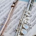 Detailed view of flutes resting on musical sheets, showcasing intricate details.