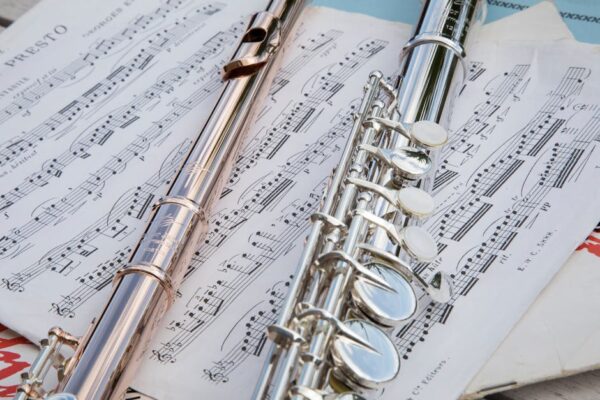 Detailed view of flutes resting on musical sheets, showcasing intricate details.