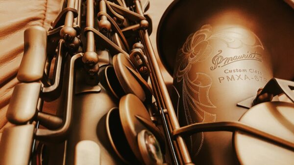 Close-up image of a vintage saxophone with intricate engraving, evoking classic musical elegance.