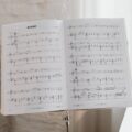 Elegant sheet music on a stand with soft natural light pouring through the window.