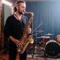 Musician passionately playing saxophone in a professional indoor music studio setting.