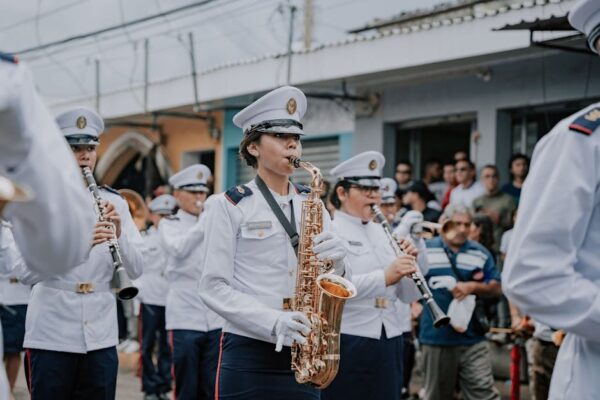 Military band playing saxophones and clarinets during a street parade in El Salvador.