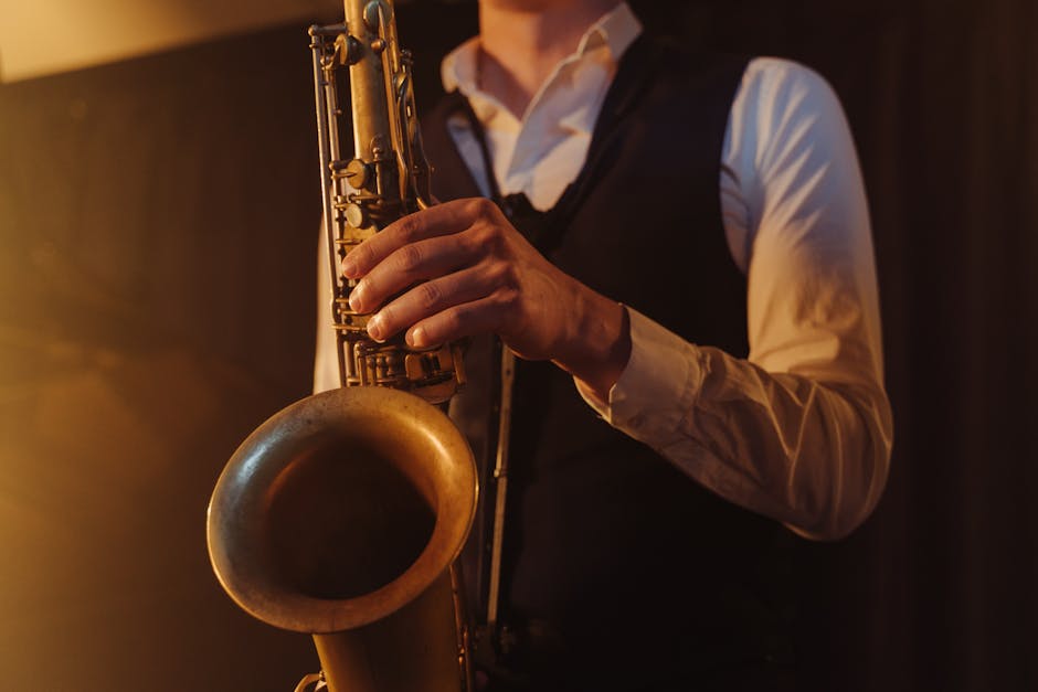Close-up of a saxophonist playing jazz music indoors, highlighting the instrument in warm lighting.