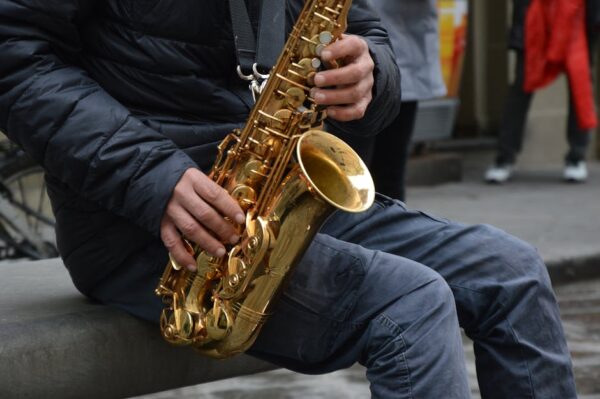 Street musician performing with a saxophone, highlighting urban performance art.