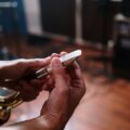 Detailed view of hands fine-tuning a saxophone mouthpiece in a music studio.