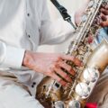 Detailed shot of a musician playing a saxophone during a performance. Captures the essence of live music.