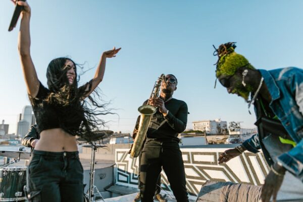 Energetic outdoor rooftop performance with diverse musicians playing instruments.