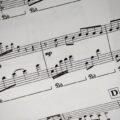 Close-up of a detailed musical sheet showcasing notes and symbols in black and white.
