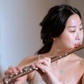 Portrait of a young woman playing the flute, showcasing skill and artistry.