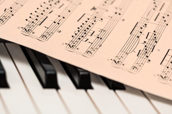Black and white piano keys with a sheet of classical music creating a harmonious composition.