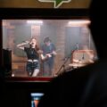 A dynamic band performance captured in a professional sound studio setting.