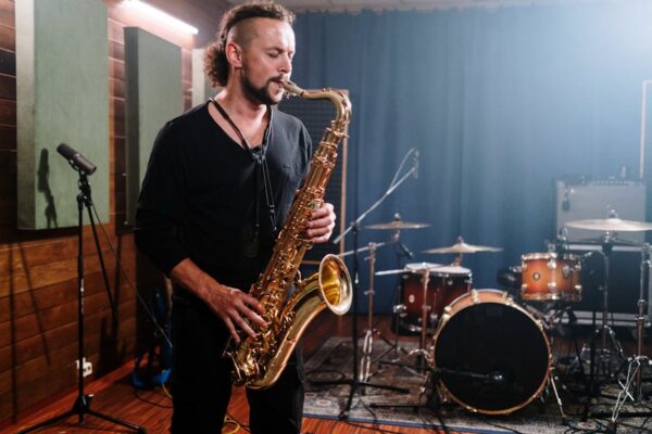Musician passionately playing saxophone in a professional indoor music studio setting.