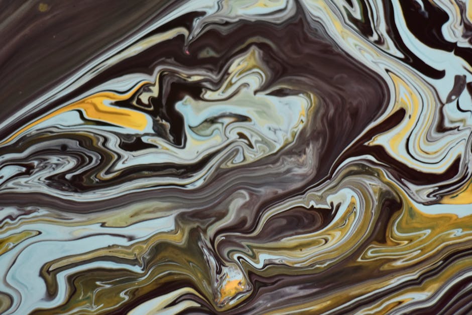 Abstract art featuring dynamic swirls of liquid paint, earthy and yellow hues.