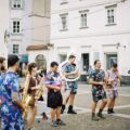 A lively street band performing with brass instruments on a city square, showcasing colorful outfits.