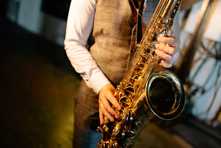 A close-up image of a saxophonist playing during an indoor performance, emphasizing the musician's skill.