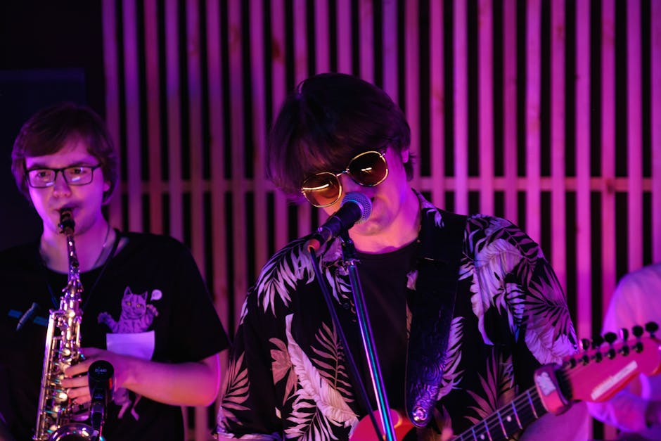 Dynamic live band performance featuring a guitarist and saxophonist under vibrant stage lighting.