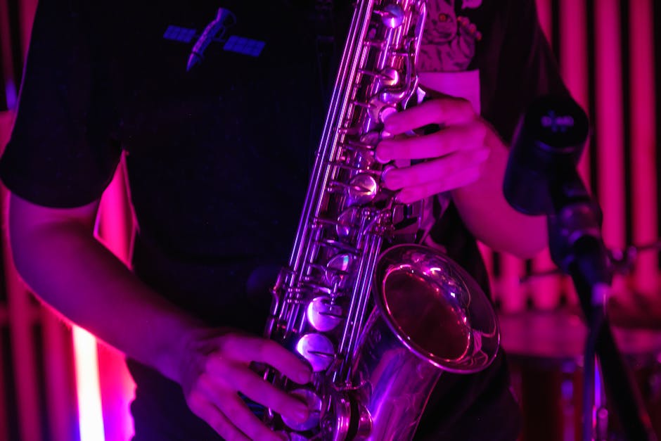 A musician plays a saxophone under vibrant purple lighting, creating a dynamic and engaging atmosphere.