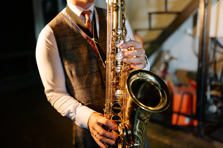 Close-up of a man in a vest playing a saxophone indoors, showcasing musical talent.