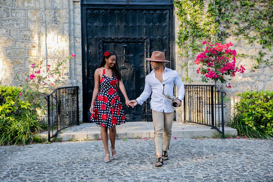 A couple holding hands while walking with a saxophone, surrounded by flowers and vibrant walls.