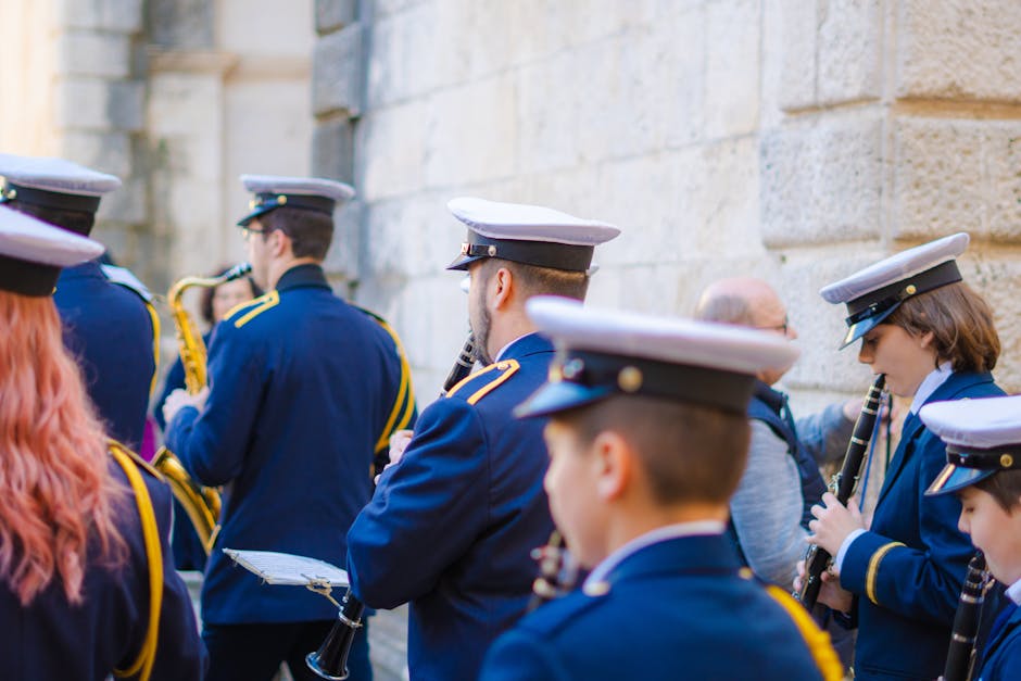 A military band performing in a street parade with various wind instruments.