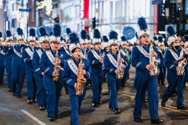 Lively parade features a brass band marching through city streets, creating a festive atmosphere.