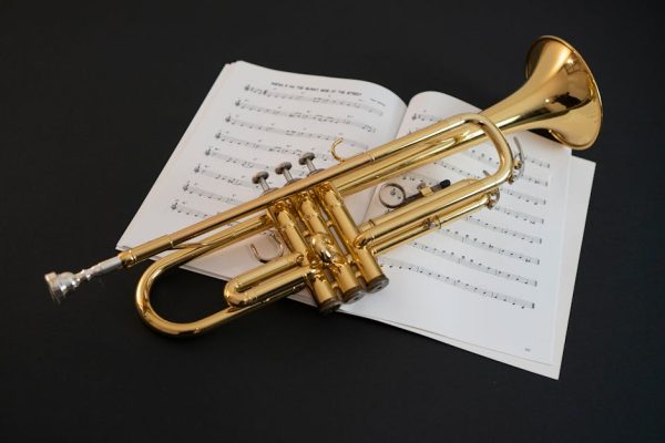 Golden trumpet resting on open sheet music, featuring melodic notes. Perfect for jazz and classical music themes.