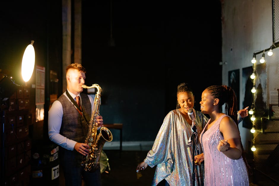 Live jazz performance featuring a saxophonist and two singers under spotlight ambiance.