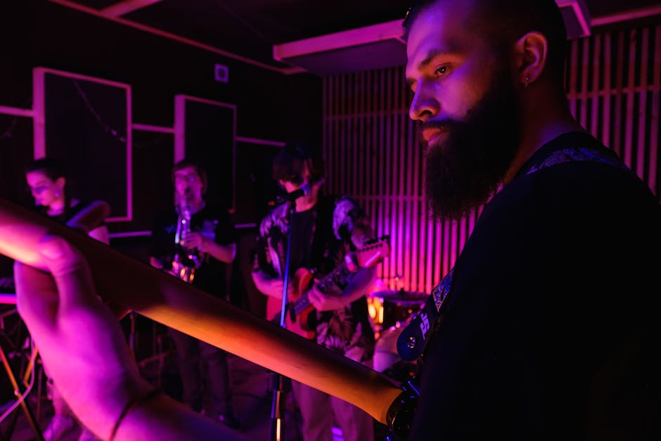 A band practicing in a music studio with vibrant lighting and various instruments.