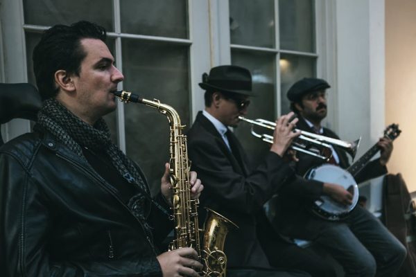 Street musicians playing saxophone, trumpet, and banjo in a classic jazz ensemble.