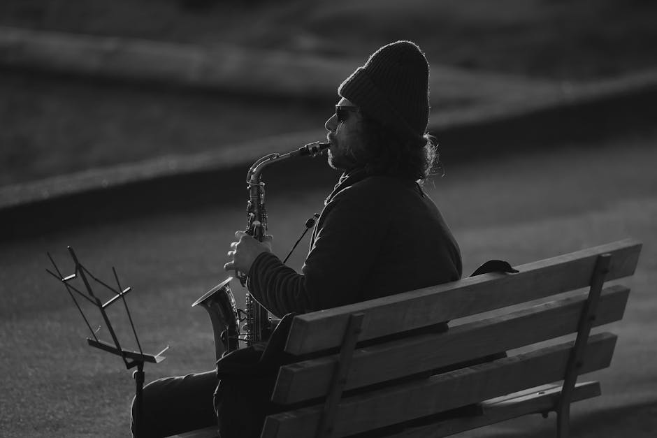 A street musician passionately playing saxophone outdoors on a bench in Vancouver.