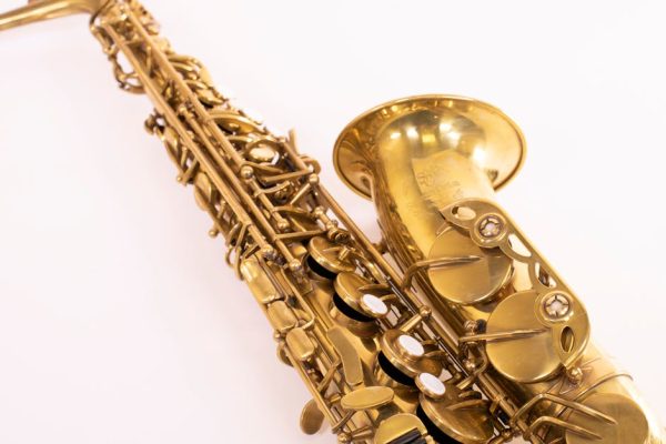 Detailed close-up of a brass saxophone, showcasing its intricate design on a plain white backdrop.