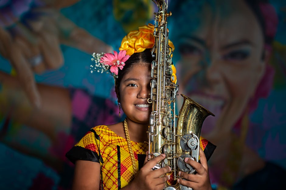 Smiling girl in traditional Oaxacan costume holding a saxophone against a colorful mural backdrop.
