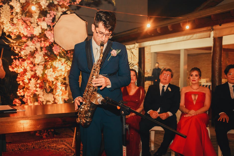 A saxophonist performs at an elegant indoor banquet with attentive guests.