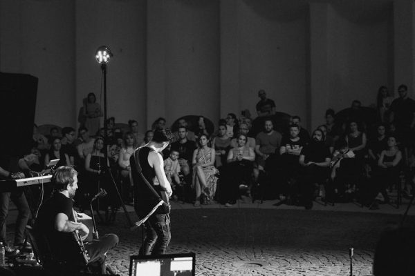 A captivating black and white image of a band performing live on stage to an attentive audience.