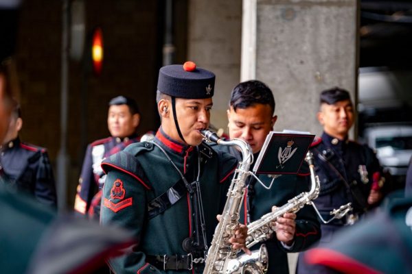 Gurkha soldiers in traditional uniform playing saxophone during a performance in England, United Kingdom.