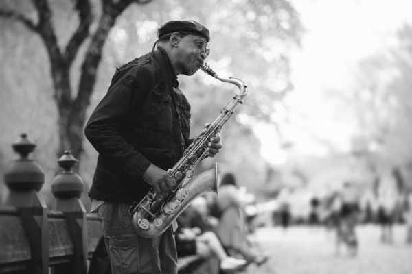 Black-and-white photo of a saxophonist performing in Central Park, NYC.