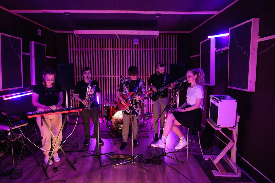 A vibrant young band rehearsing with musical instruments under neon lights in a studio setting.
