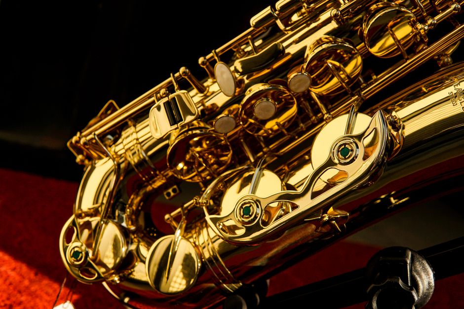 Detailed close-up of a shiny gold saxophone showcasing intricate details and reflections.