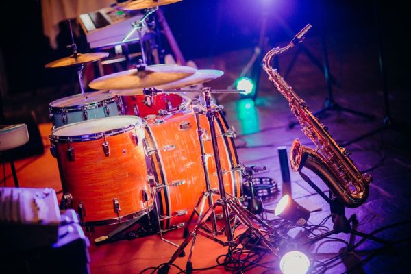 Close-up of drums and saxophone on stage with bright lights, perfect for a concert theme.